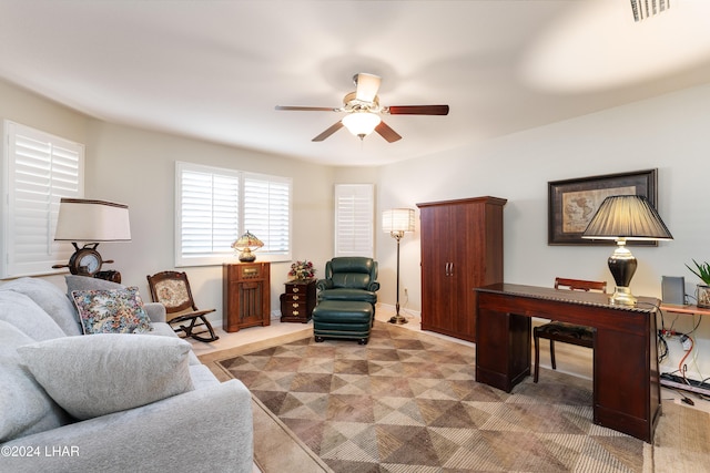 living area with baseboards, carpet, visible vents, and a ceiling fan