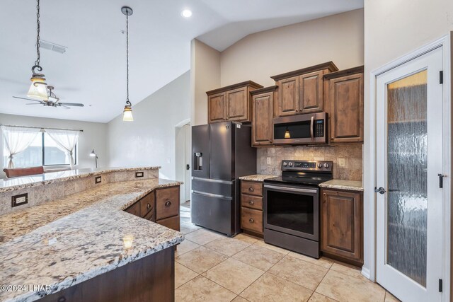 kitchen with vaulted ceiling, appliances with stainless steel finishes, pendant lighting, tasteful backsplash, and light stone countertops