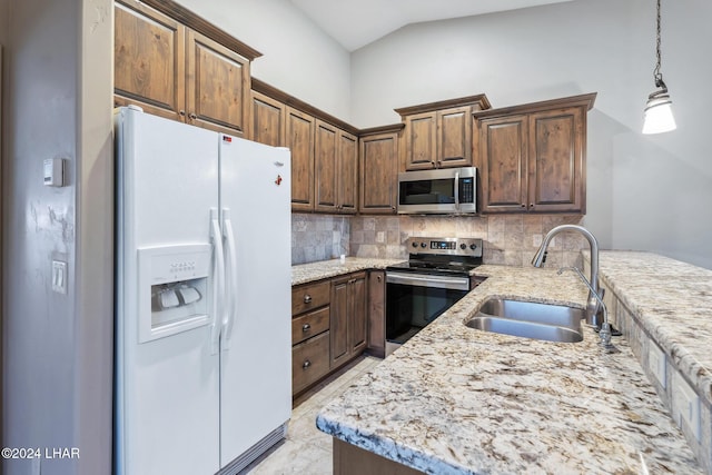 kitchen featuring hanging light fixtures, appliances with stainless steel finishes, sink, and decorative backsplash