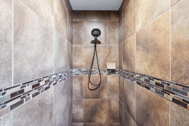 interior details featuring a tile shower