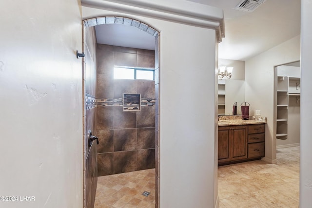 bathroom with vanity and a tile shower