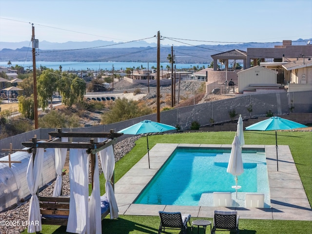 view of swimming pool featuring a mountain view and a lawn