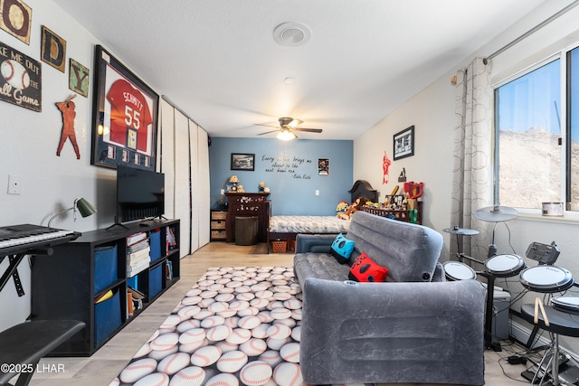 living room with ceiling fan and light hardwood / wood-style floors