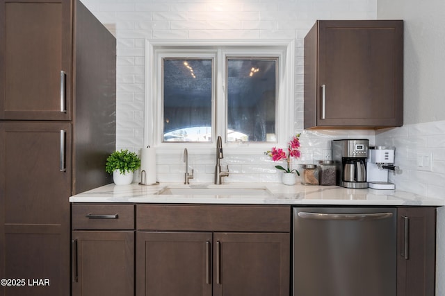 kitchen featuring dishwasher, sink, light stone countertops, and backsplash