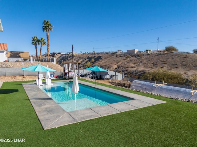 view of swimming pool with a yard