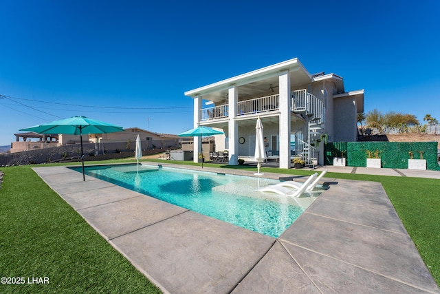 view of swimming pool with a patio area, ceiling fan, and a lawn