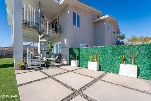 view of property exterior featuring a balcony and a patio