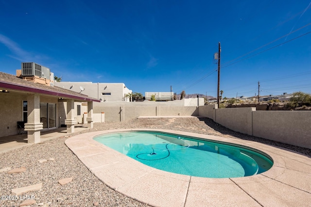 view of pool featuring a fenced in pool, a patio area, a fenced backyard, and central air condition unit