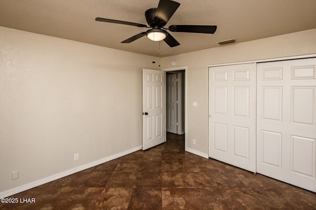 unfurnished bedroom with a textured ceiling, a ceiling fan, visible vents, baseboards, and a closet