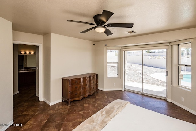 unfurnished bedroom with a textured ceiling, access to outside, visible vents, and baseboards