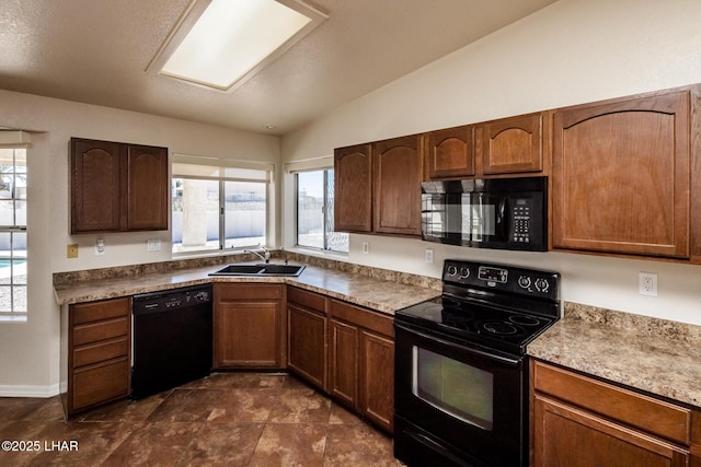 kitchen with lofted ceiling, black appliances, a sink, and a wealth of natural light