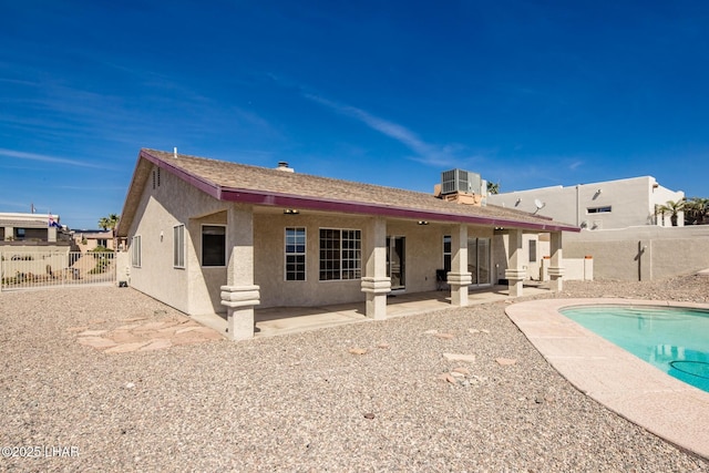 rear view of house featuring a fenced in pool, fence, cooling unit, a patio area, and stucco siding