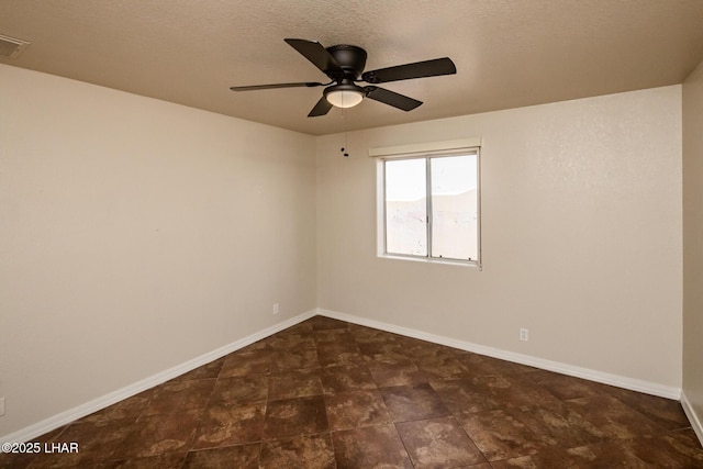 empty room with ceiling fan, baseboards, and a textured ceiling