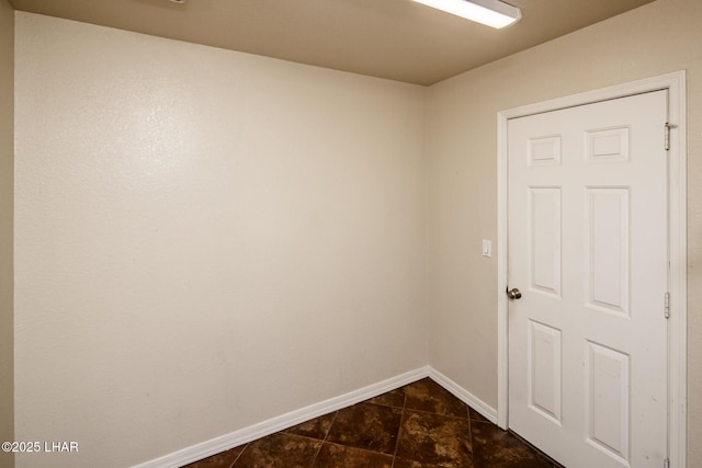 unfurnished room featuring baseboards