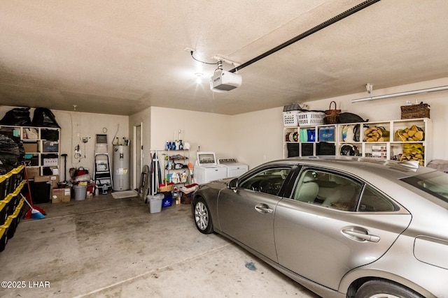 garage featuring water heater, washing machine and dryer, and a garage door opener