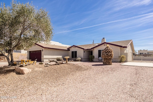 single story home featuring a garage, fence, a chimney, and stucco siding