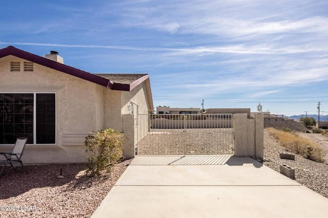 view of property exterior featuring a patio, fence, and stucco siding