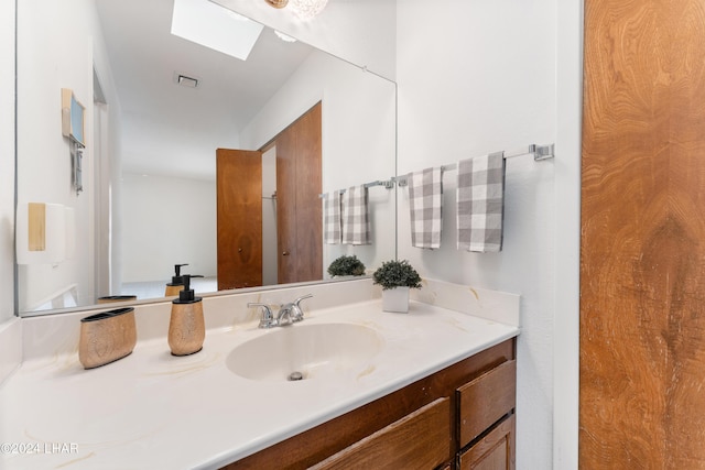 bathroom featuring vanity and a skylight