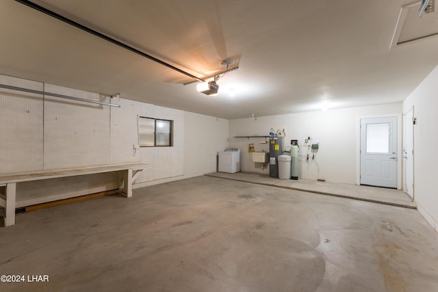 garage with a garage door opener, washer and dryer, sink, and a workshop area