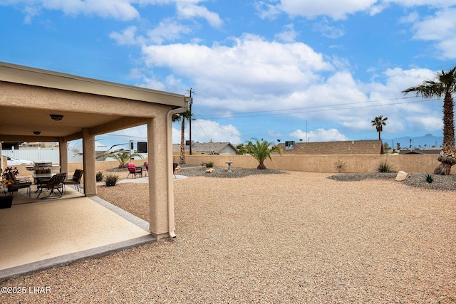 view of yard with a patio area, a fenced backyard, and outdoor dining area