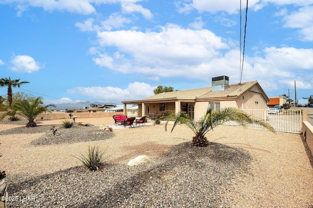 rear view of property featuring a patio area, a fenced backyard, and stucco siding