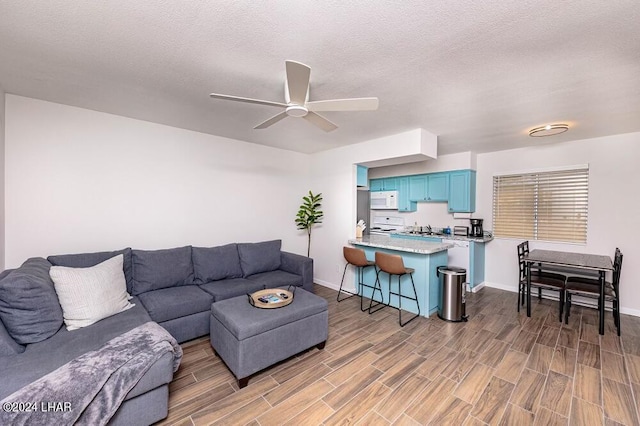 living room with a textured ceiling and ceiling fan