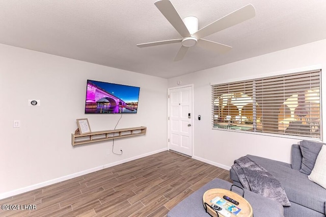 living room with hardwood / wood-style floors, a textured ceiling, and ceiling fan