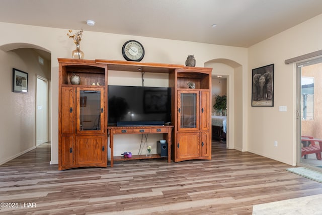 406 Noland Ct, Lake Havasu City, AZ 86403 - unfurnished living room with arched walkways, light wood-style floors, and baseboards