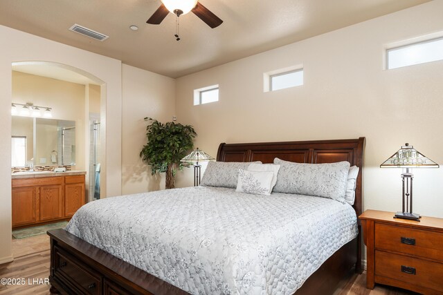 406 Noland Ct, Lake Havasu City, AZ 86403 - bedroom with light wood-style floors, arched walkways, connected bathroom, and ceiling fan