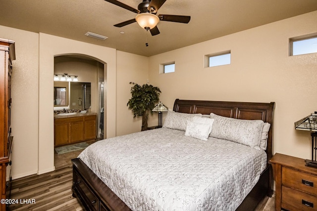 bedroom with connected bathroom and dark hardwood / wood-style flooring