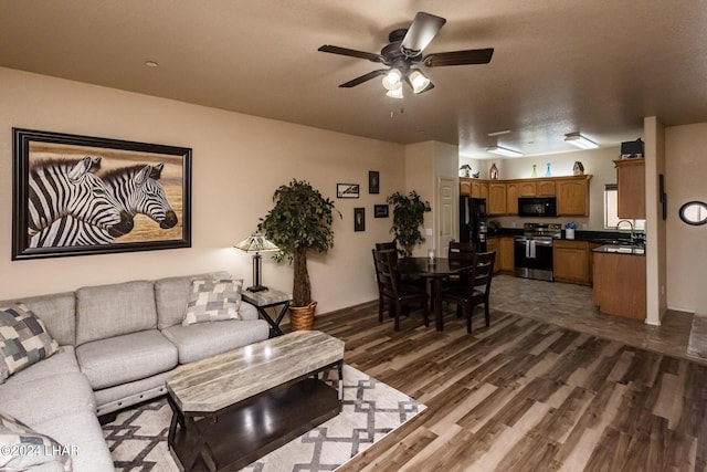 living room with sink, dark hardwood / wood-style floors, and ceiling fan