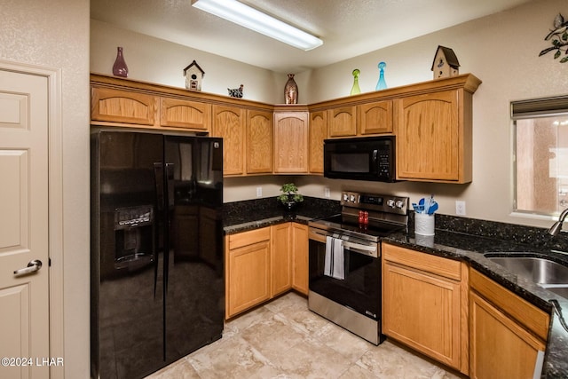 kitchen with sink, black appliances, and dark stone counters