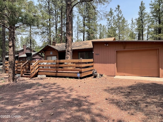 7681 E Robin Hood Rd, Williams, AZ 86046 - view of front of house with a garage, a wooden deck, driveway, and a chimney