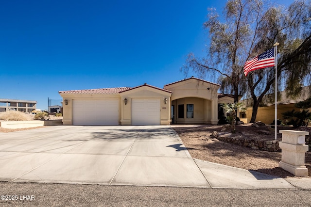 mediterranean / spanish home featuring driveway, a tiled roof, an attached garage, and stucco siding