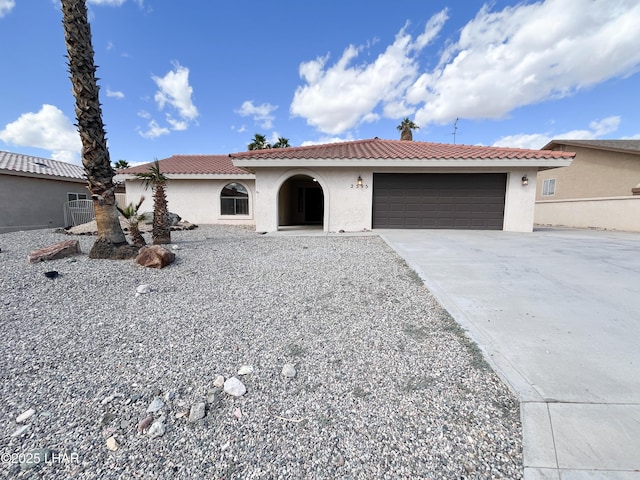 mediterranean / spanish-style home featuring a garage, a tile roof, and stucco siding