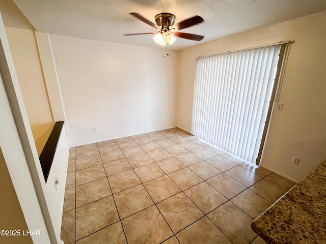 empty room featuring ceiling fan and light tile patterned floors