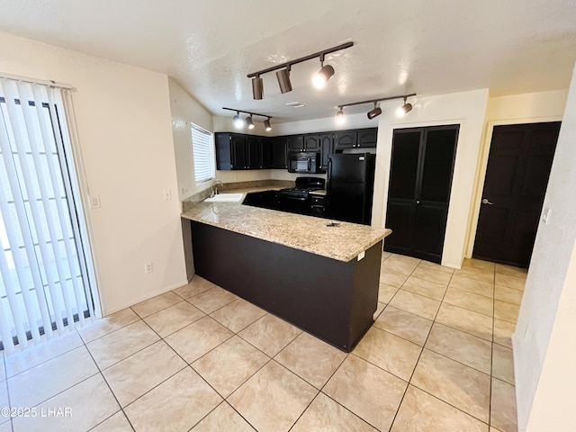 kitchen featuring a peninsula, black appliances, a sink, and light tile patterned flooring