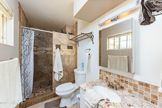 bathroom featuring vanity, tasteful backsplash, toilet, and walk in shower