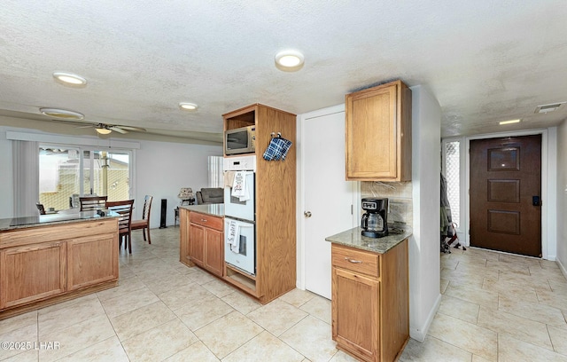 kitchen with ceiling fan, white double oven, and a textured ceiling