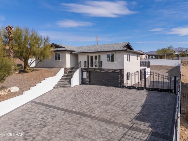 single story home with a garage, stone siding, stairs, a gate, and stucco siding