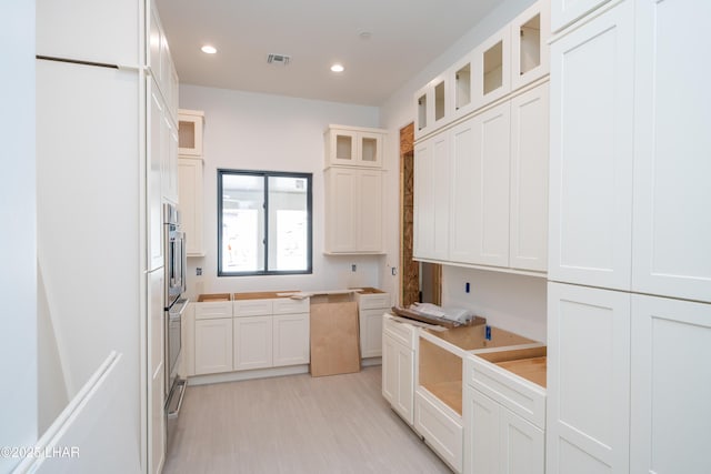 6724 Corte De Los Bueyes, Lake Havasu City, AZ 86404 - kitchen with glass insert cabinets, recessed lighting, white cabinets, and light wood-type flooring