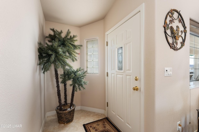 entryway with light tile patterned floors and baseboards