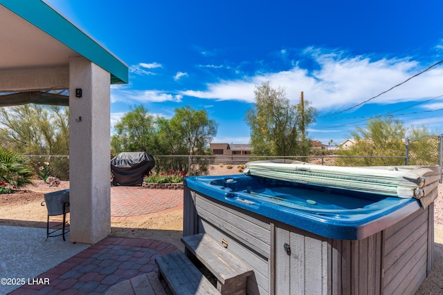 view of patio with fence and a hot tub