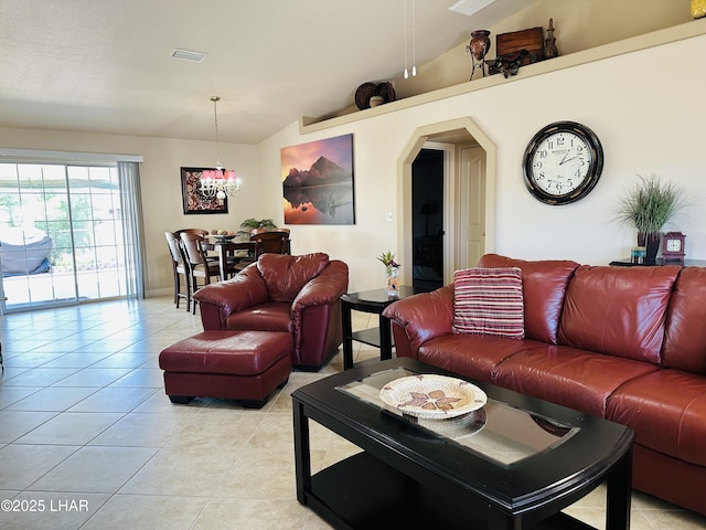 living area featuring vaulted ceiling, visible vents, light tile patterned floors, arched walkways, and a chandelier