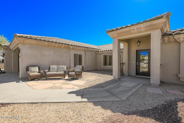 rear view of property with a patio area, stucco siding, an outdoor hangout area, and a tiled roof