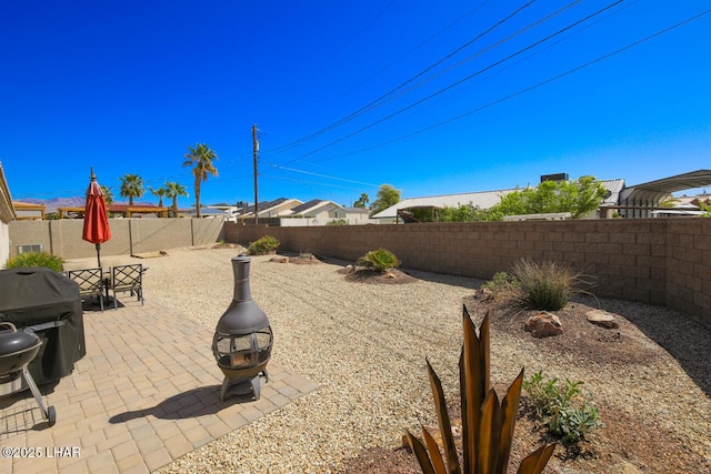 view of yard featuring a patio, a fire pit, and a fenced backyard