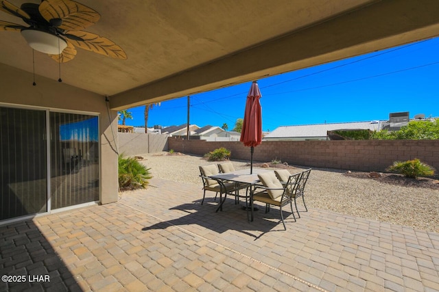 view of patio featuring outdoor dining area, a fenced backyard, and ceiling fan