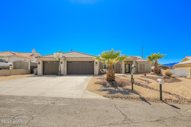 view of front of home featuring fence, stucco siding, concrete driveway, a garage, and a tiled roof