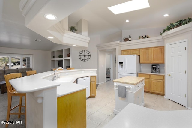 kitchen featuring white appliances, light tile patterned floors, a kitchen island with sink, a sink, and open floor plan