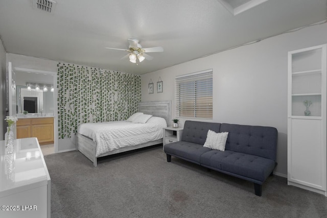 carpeted bedroom featuring connected bathroom, visible vents, and ceiling fan